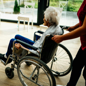 nurse pushing a wheelchair patient